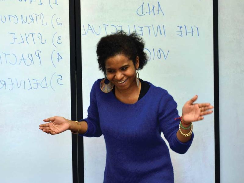 A Black woman who's a speaking fellow looks happy with her presentation
